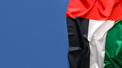 UAE national fabric flag on blue background