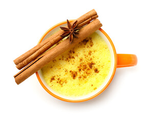 Cup of tasty turmeric latte with star anise and cinnamon on white background