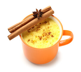 Cup of healthy turmeric latte with star anise and cinnamon on white background