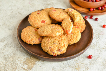 Plate with delicious cranberry cookies on light background