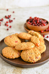 Plate with delicious cranberry cookies on light background, closeup