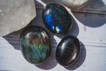 overhead photo of labradorite and hypersthene palm stones with flash