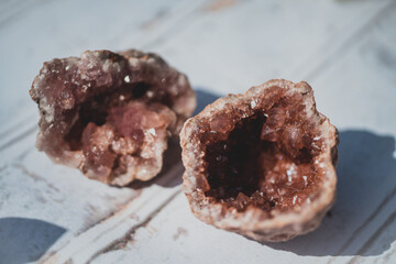 raw pink amethyst geodes on white wood