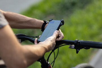 Man planning route using GPS navigation application in mobile phone on his bicycle bike. Plugging device