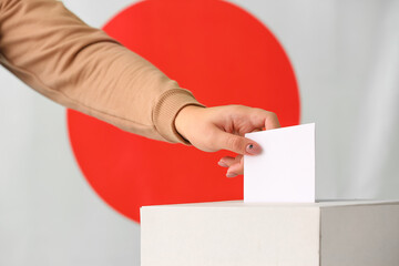Voting woman near ballot box against flag of Japan