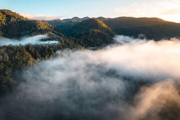 The sun rises in the mist and mountains in the morning