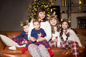 Portrait happy christmas family mom and four children wearing in pajamas celebrating christmas at home together