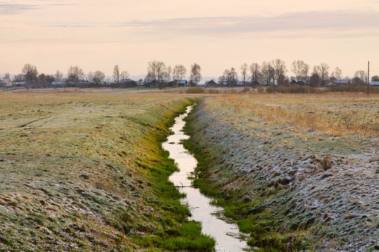 irrigation ditch near a small village in autumn