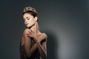 attractive woman in a golden dress with a crown on her head decoration studio