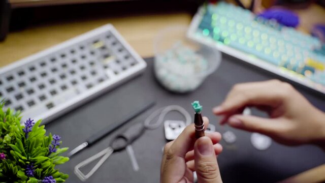 Footage of a person lubing linear switch for custom build mechanical DIY keyboard.
