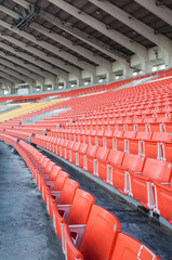 Obraz premium Empty orange seats at stadium,Rows walkway of seat on a soccer stadium
