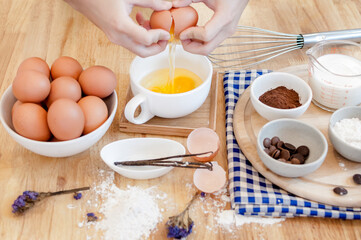 Man in the kitchen cooking a dough. Hands breaks an egg into a bowl ,hands pouring bitten egg ,Baking concept