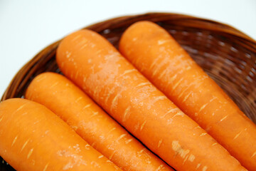 白背景にあるザルの中の複数の人参