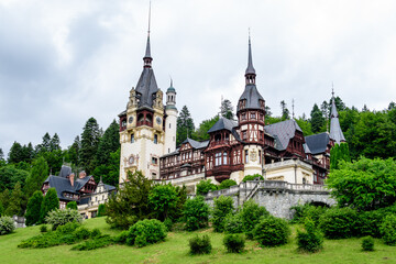 Obraz premium Beautiful neo-Renaissance building of Peles Castle (Castelul Peles) near Bucegi Mountains (Muntii Bucegi) in a cloudy summer day in Sinaia town, Romania .