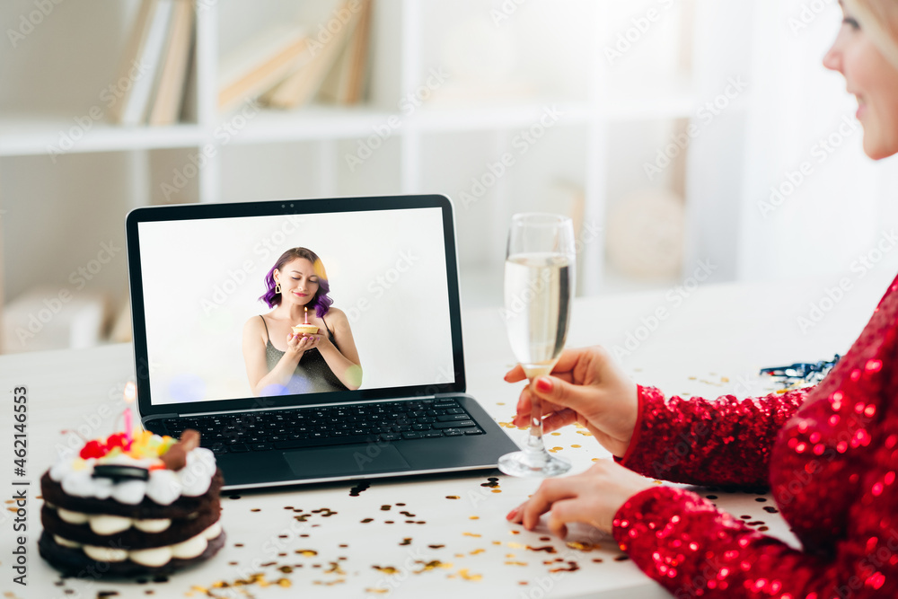 Sticker Happy birthday. Virtual greeting. Online conference. Unrecognizable woman with champagne looking laptop screen pretty female friend festive cake light room interior.