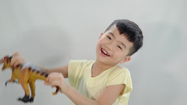 asian chinese kid playing his t-rex toy