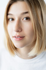 Attractive woman portrait. Skin care. Natural beauty. Closeup of gorgeous young fresh model with freckles perfect smooth face in daylight.