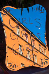 Stockholm, Sweden Buildings reflected in a mirror of a hair salon and  a sign saying Girls, Girl, Girls.