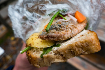 Stockholm, Sweden A herring sandwich with potatoes and dill on bread in a plastic wrap.