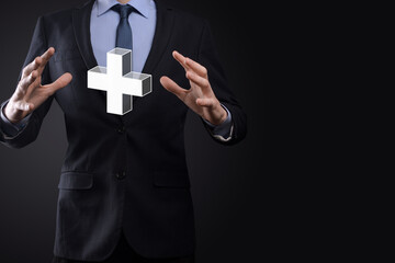 Businessman hold 3D plus icon, man hold in hand offer positive thing such as profit, benefits, development, CSR represented by plus sign.The hand shows the plus sign