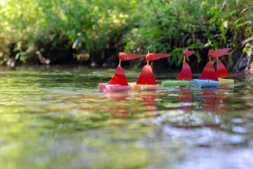 Sports regatta of children's toy ships on the creek. Five homema