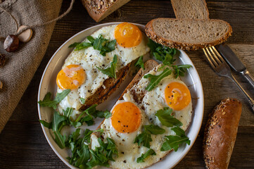 Sandwich with fried eggs sunny side up and arugula