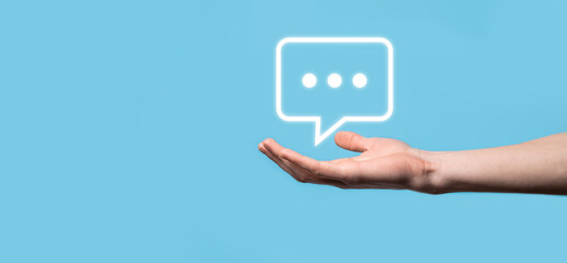 Businessman holding a message icon, bubble talk notification sign in his hands. Chat icon, sms icon, comments icon, speech bubbles