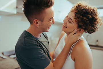 Lovers laughing in the kitchen - obrazy, fototapety, plakaty