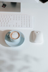 Light blue coffee cup flat lay with computer and table, minimalism and mood
