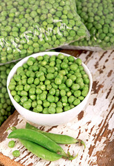 Green pea in bowl of top view on rustic wooden background with copy space, natural wooden table.