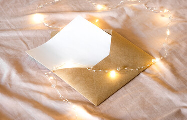 envelope with a letter lies on the bed along with a Christmas garland