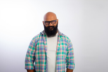 Indian bald man wearing casual clothes and glasses looking at camera and smiling 