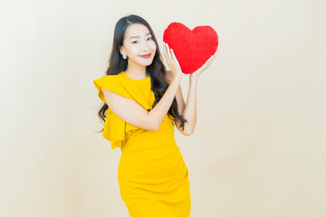 Portrait beautiful young asian woman smile with heart pillow shape