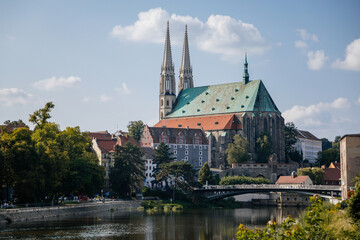 Goerlitz, Germany, 04 September 2021: gothic medieval St. Peter and Paul Church or Peterskirche with two white towers in historical center of city at sunny summer day, Riverbank of Lusatian Neisse