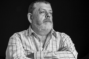 Nice black and white portrait of a thoughtful Caucasian, bearded senior man in light shirt