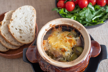 roast in a clay pot with bread and tomatoes