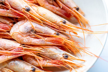 Boiled unpeeled northern shrimp on a plate, close-up. Marine delicacy of the order of crustaceans