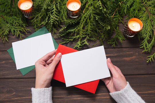 Woman's Hands Holding Blank Paper Greeting Or Invitation Card. Chritsmas Design.