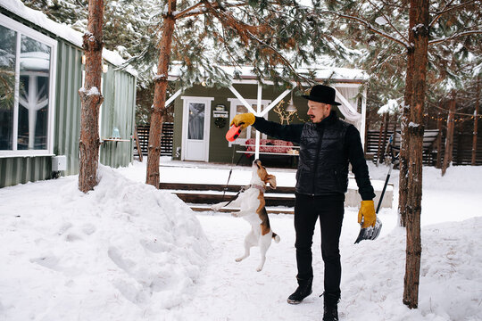 Dressed In Black Man Playing With A Happy Beagle Dog, Teasing Her, Making Jump