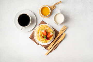 Morning served breakfast set: pancakes, porridge, cottage cheese, granola, muesli, orange juice, tea, coffee, fruits and berries.