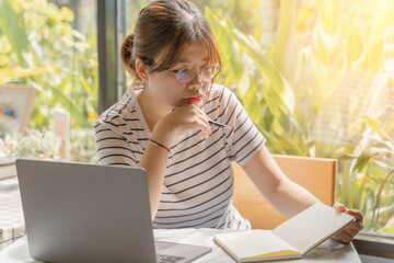 Happy young Asian businesswoman using computer laptop for learning, studying in money investing, trading on Cryptocurrency as Bitcoin, stock market, on online business class at home. investing concept