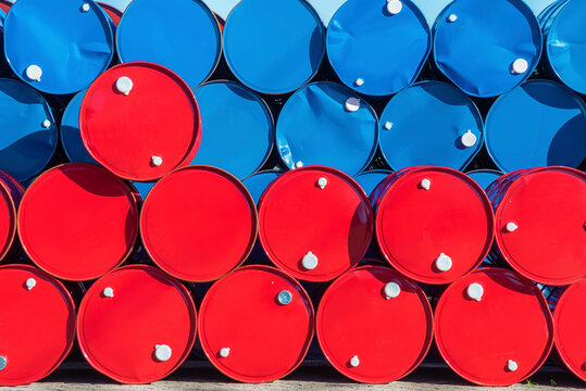 Colorful oil barrel stacked in row. Industrial background