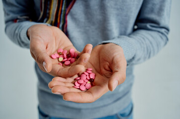 sick man treating the disease with pills in hands isolated background