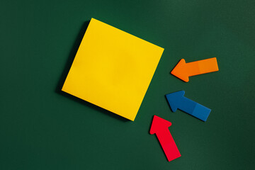 Yellow Square Blank note and three small arrows on a green background. Short Note. Paper stick note