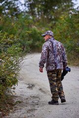 professional photographer in camouflage clothes working in nature.