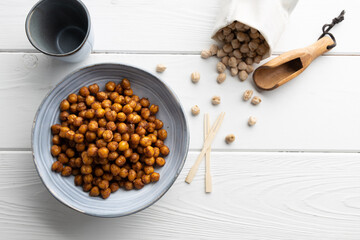 Vegan grilled chickpeas. Homemade vegan chickpeas, Crispy roasted organic chickpeas . Served as a snack in a bowl, on a white background.
