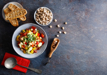 Homemade chickpea salad. Homemade healthy vegan salad, with chickpea , tomato, cucumber, paprika served in a bowl. Healthy meal, on a dinner table.