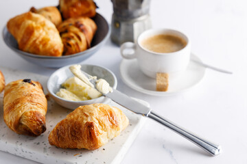 Morning breakfast with croissants. Breakfast table with croissants and coffee, on a marble stone table.