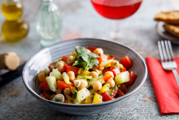 Homemade chickpea salad. Homemade healthy vegan salad, with chickpea , tomato, cucumber, paprika served in a bowl. Healthy meal, on a dinner table.