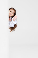 One cute beautiful little girl playing isolated on white studio background. Human emotions, facial expression concept.